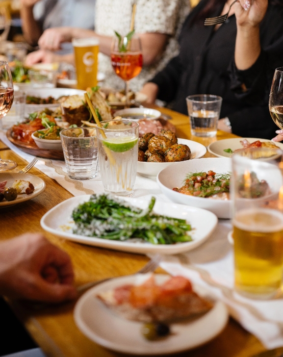 A group of people sitting at a table with plates of food in a restaurant in Perth CBD.