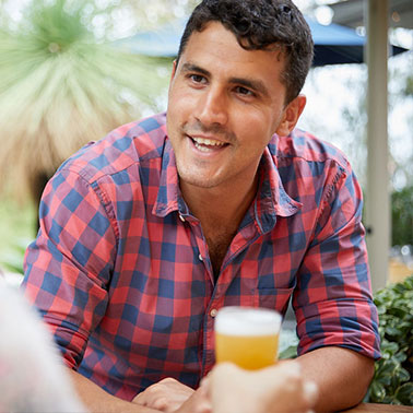 A man enjoying a glass of beer at a table in a brewery in Perth.