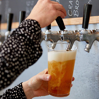 Person pouring beer into glass at brewery in Perth.