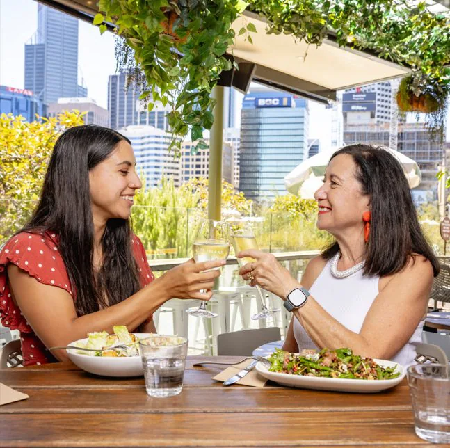 Mother and daughter enjoying Mother's Day lunch in Perth with a stunning city view.